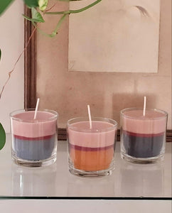 A trilogia de velas decorativas tri-colores são fabricadas à mão dentro dos vidros com um tamanho de 8cm de diâmetro e 8cm de altura.  A composição da vela é feita com cera a base de soja eco mix, corante anilina e pavio de algodão.  O processo de fabricação  das velas tri-color  consiste em três tempos de secagem e camadas; três cores de base sendo cinza claro, açafrão e cinza chumbo, no meio uma listra em magenta e encima beige rosé .